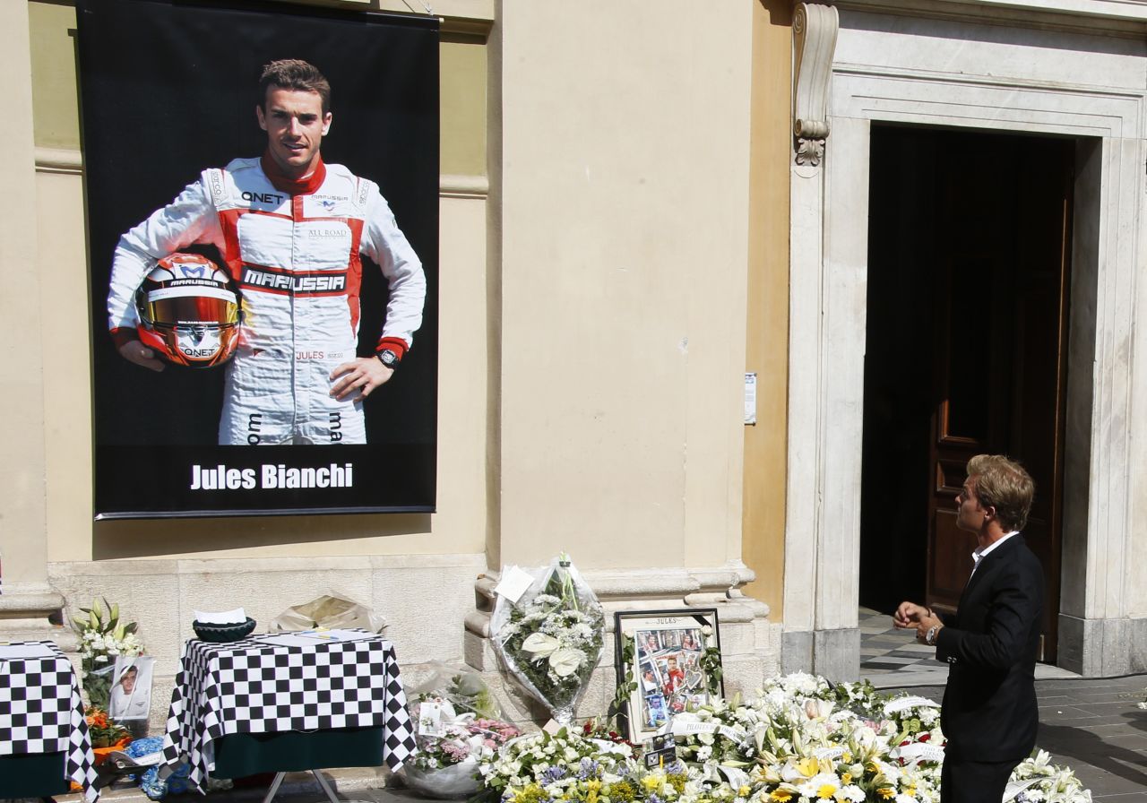 Mercedes driver Nico Rosberg pauses at the main entrance to the cathedral where tributes had been lain below a portrait of Jules Bianchi in his Marussia racing suit.