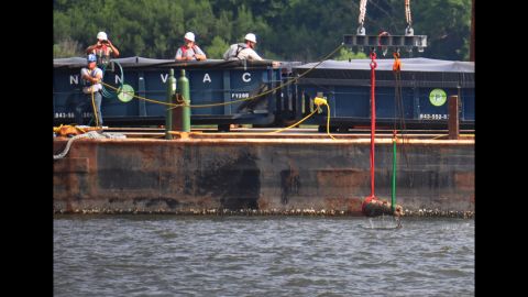 The first of four cannons to be removed from the CSS Georgia by U.S. Navy divers is lifted to a barge in the Savannah River on July 15.