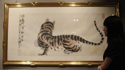 A woman looks at a painting entitled 'Tiger' by Qi Baishi, which is expected to fetch over 3.6 million USD at an auction in Hong Kong on March 4, 2010.