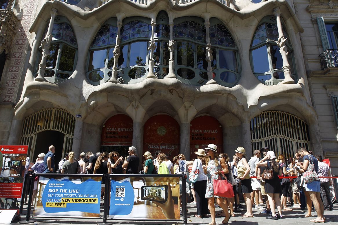 Tourists queue to visit Spanish architect Antoni Gaudí's landmak, Casa Batlló, in Barcelona on June 28, 2015.