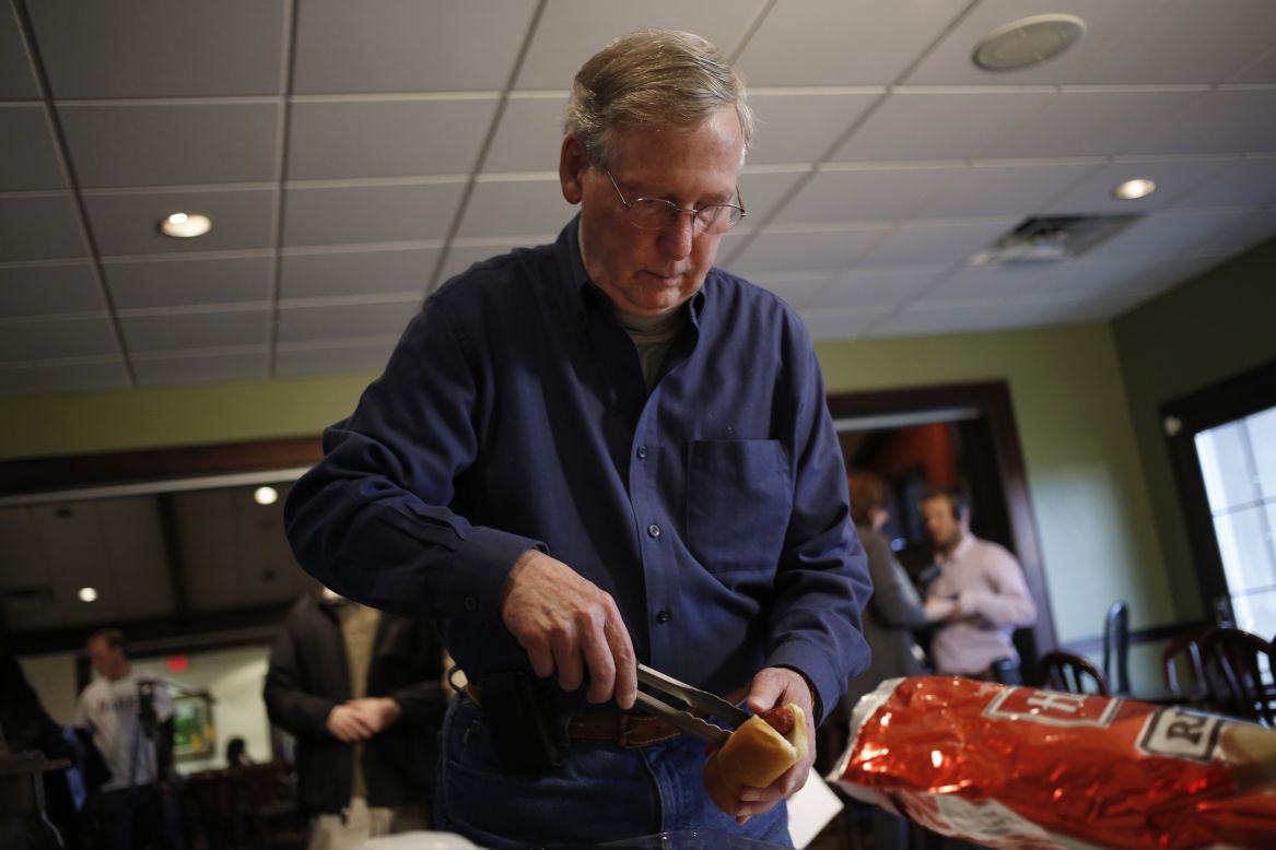 Then-Senate Minority Leader Mitch McConnell, R-Kentucky, serves himself a hot dog after speaking at a campaign rally and hot dog roast at the Old Silo Golf Course and Clubhouse on November 1, 2014, in Mount Sterling, Kentucky. 