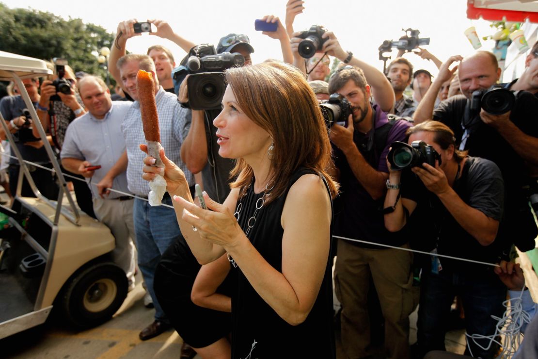 Then-Republican presidential candidate Rep. Michele Bachmann (R-MN) shows off her foot-long corn dog as photographers take her picture at the Iowa State Fair August 12, 2011 in Des Moines, Iowa.