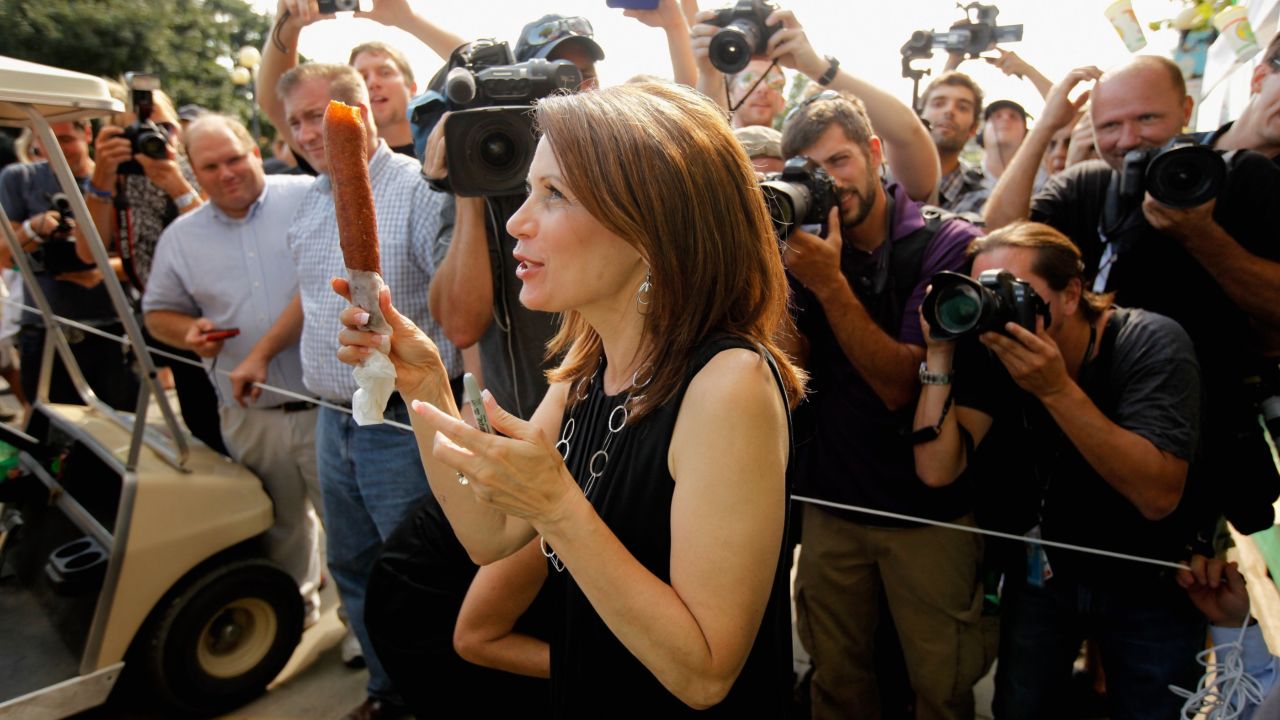 Then-Republican presidential candidate Rep. Michele Bachmann (R-MN) shows off her foot-long corn dog as photographers take her picture at the Iowa State Fair August 12, 2011 in Des Moines, Iowa.