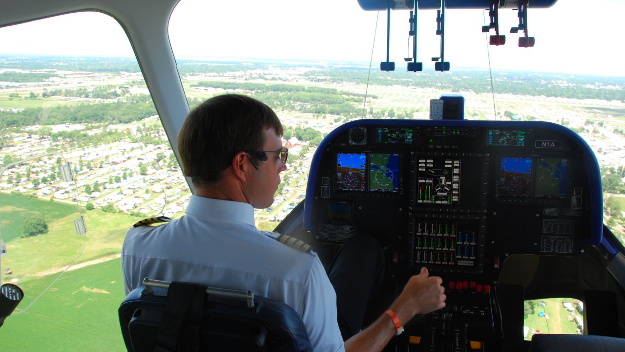 Goodyear Zeppelin pilot Michael "Doc" Dougherty steers the airship above Oshkosh's annual aviation festival on Thursday.
