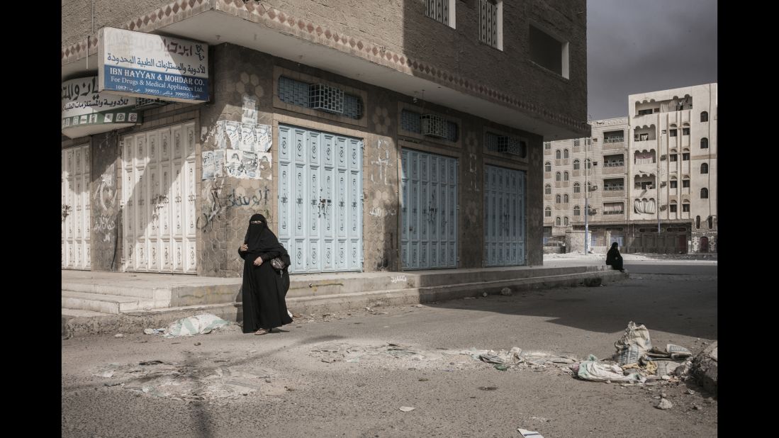 A woman walks in what seems to be a mostly deserted area of the city.