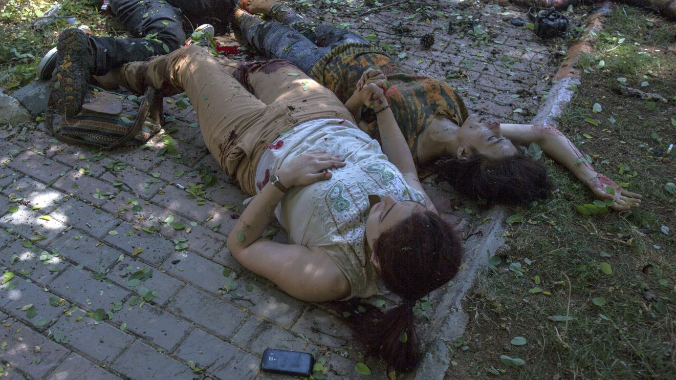 A wounded woman, left, holds the hand of another woman who is about to die just after <a href="http://www.cnn.com/2015/07/20/world/gallery/terror-attack-turkey/index.html" target="_blank">an explosion rocked the Turkish city of Suruc</a> on Monday, July 20. More than 30 people were killed and at least 100 others were wounded in what Turkish officials called a terrorist attack near the Syrian border.