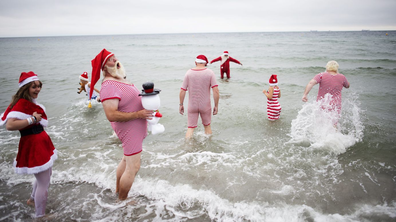 Participants from the World Santa Claus Congress enter the water at Bellevue Beach, north of Copenhagen, Denmark, on Tuesday, July 21.