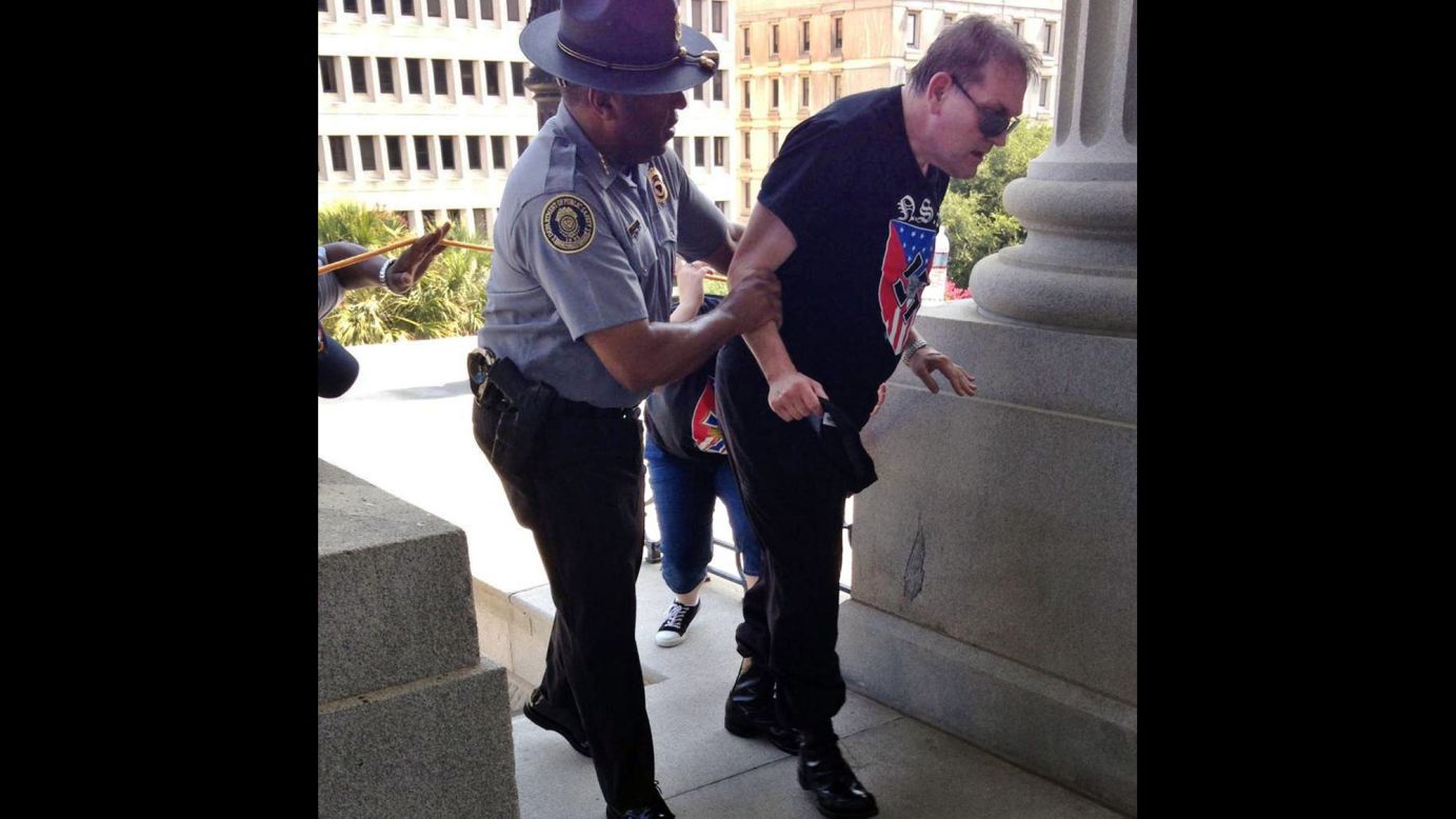As white supremacists were protesting the removal of the Confederate flag from the South Carolina State House grounds, Public Safety Director Leroy Smith helped a man who was struggling from the heat on Saturday, July 18. The photo <a href="http://www.cnn.com/2015/07/19/us/black-officer-white-supremacist-feat/" target="_blank">spread through social media</a> after Rob Godfrey, deputy chief of staff to South Carolina Gov. Nikki Haley, tweeted the photo with the caption, "not an uncommon example of humanity in SC." 