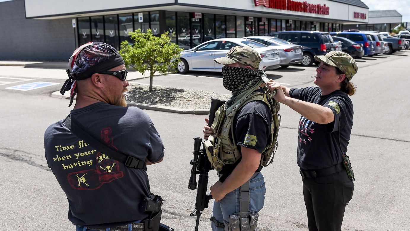 Crystina Page Steinmetz helps a man tie on a bandana as their small group stands guard outside a military recruiting center in Colorado Springs, Colorado, on Wednesday, July 22. <a href="http://www.cnn.com/2015/07/22/us/armed-civilians-guard/" target="_blank">Gun-toting civilians</a> have been showing up at military recruiting centers around the country, saying they plan to protect recruiters following last week's killing of four Marines and a sailor in Chattanooga, Tennessee.<br />