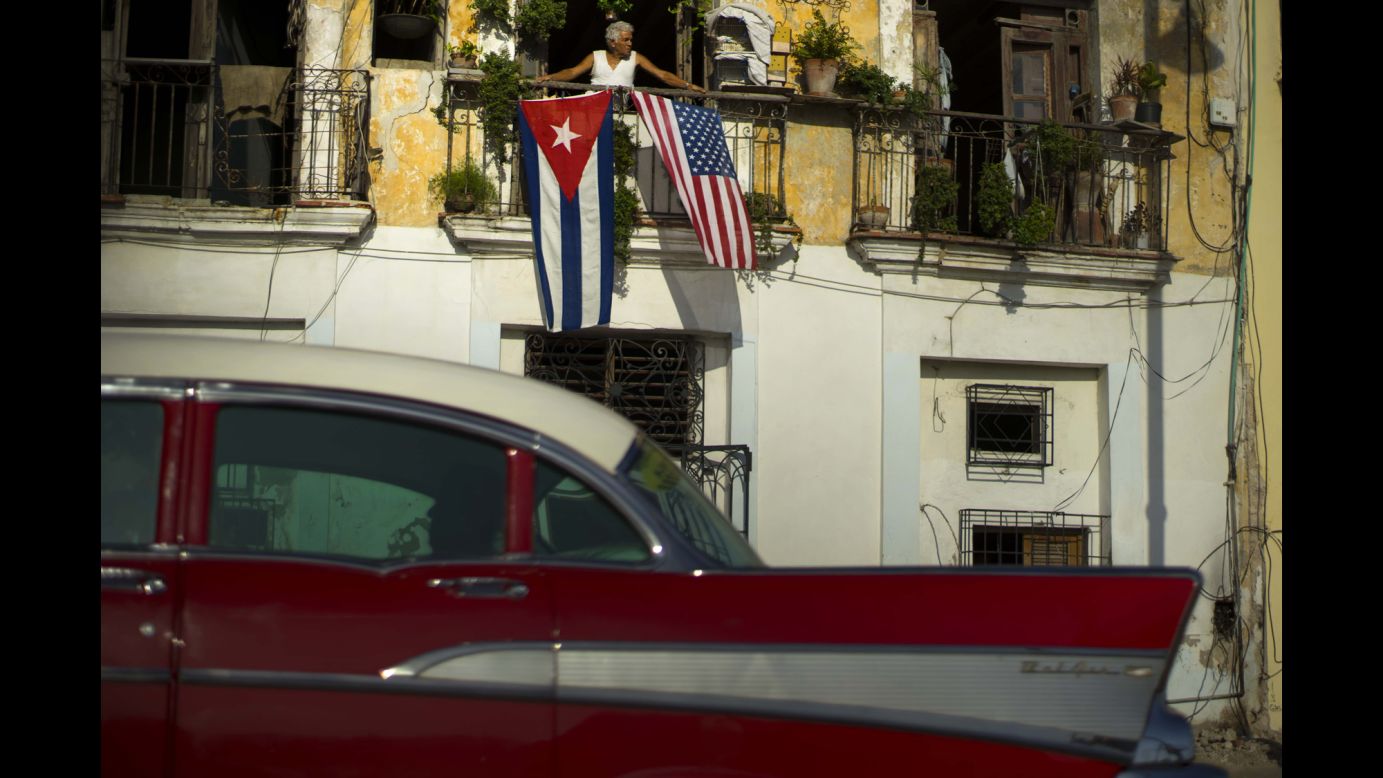Javier Yanez looks out from his balcony in Havana, Cuba, where he hung the national flags of Cuba and the United States on Monday, July 20. The two countries <a href="http://www.cnn.com/2015/07/20/politics/cuba-u-s-embassies-opening/" target="_blank">have re-established diplomatic relations</a> for the first time since 1961.