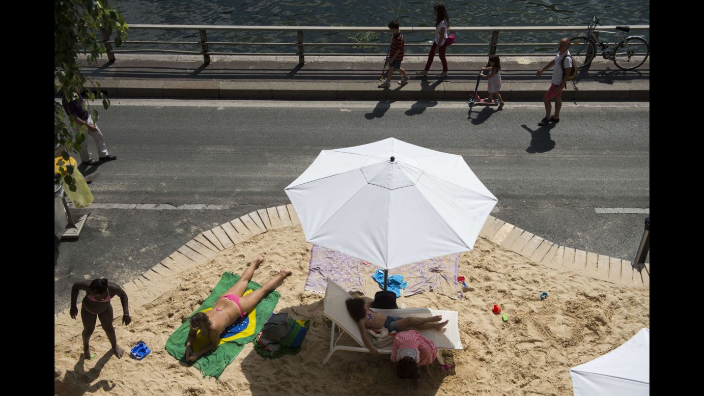 People in Paris relax on an artificial beach set up on the banks of the Seine river on Tuesday, July 21.