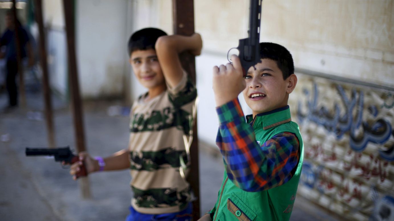 Young Syrian refugees play with toy guns at a camp in Mafraq, Jordan, on Friday, July 17. They were celebrating the first day of Eid al-Fitr, the festival marking the end of Ramadan.