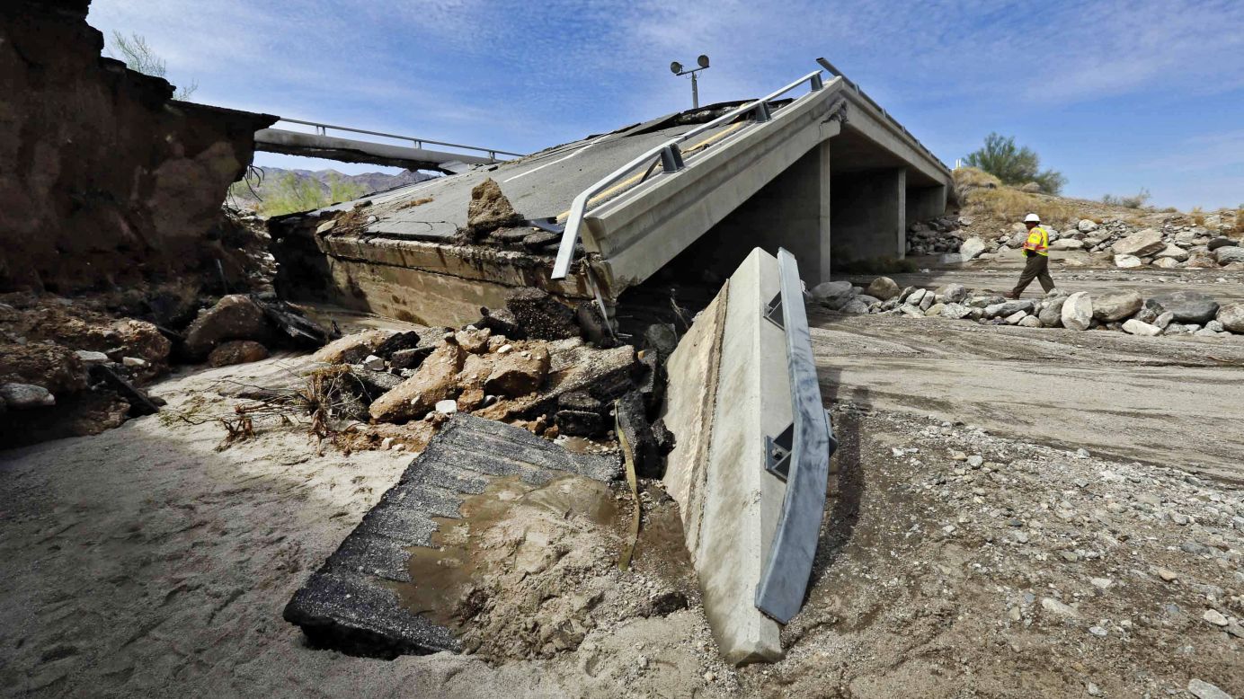 A worker walks near a washed-out bridge near the town of Desert Center, California, on Monday, July 20. Traffic on Interstate 10 was blocked indefinitely when the bridge collapsed during a major storm.