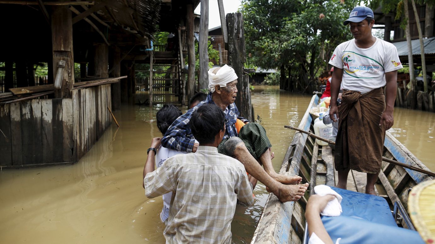 People carry an old man in a flooded village in Kawlin, Myanmar, on Tuesday, July 21.