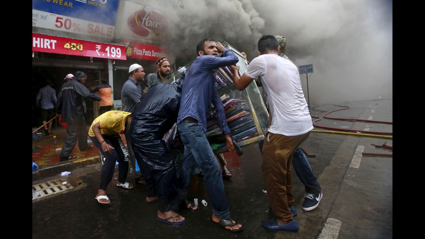 People retrieve items from a store during a fire at a shopping complex in Mumbai, India, on Tuesday, July 21.