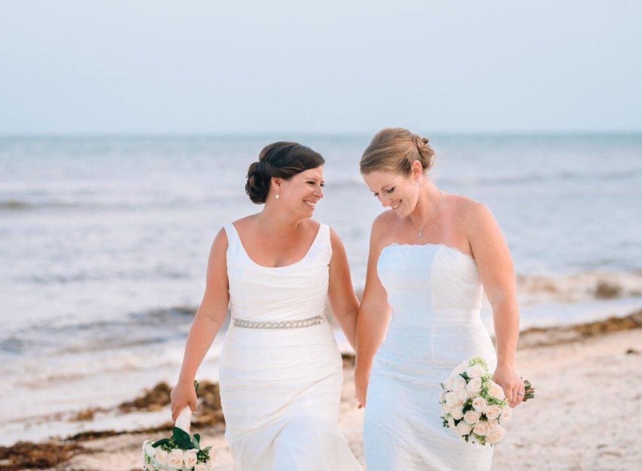 Long Beach, New York, couple Lauren, left, and Christine Rapkin smile on their wedding day June 25, 2015, in Puerto Morelos, Mexico. They have been together for eight years and wed the day before the landmark Supreme Court decision. Christine is a critical care nurse and Lauren is an event planner and together they enjoy kayaking, beach volleyball and hiking with their dog. Photo courtesy<a href="http://nicolebarrphotography.com/" target="_blank" target="_blank"> Nicole Barr Photography.</a>