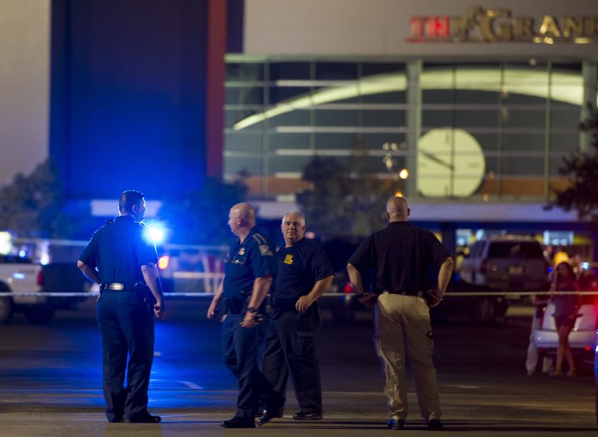 Law enforcement personnel stand near a police line at The Grand Theatre following a deadly shooting in Lafayette, Louisiana, on Thursday, July 23. The shooter in the Lafayette movie theater shooting died of a self-inflicted gunshot wound according to Louisiana State Police.