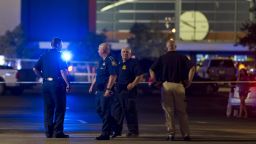 Law enforcement personnel stand near a police line at The Grand Theatre following a deadly shooting in Lafayette, La., Thursday, July 23, 2015. (Paul Kieu/The Daily Advertiser via AP)