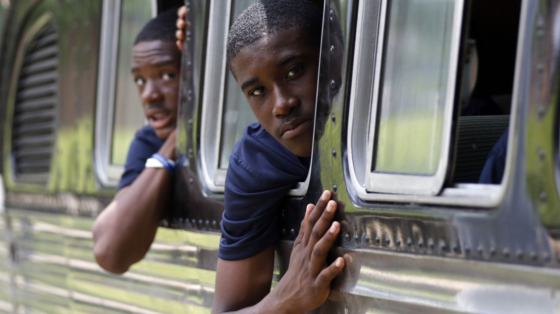 Tamir Brooks, right, and Sami Wylie look out the windows of the 1947 vintage bus their team traveled on this summer.