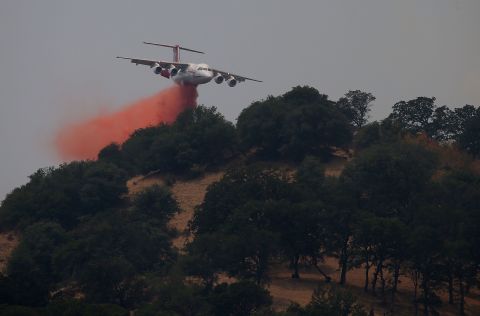 A firefighting aircraft drops retardant on a ridge to combat the Wragg Fire on July 23. 