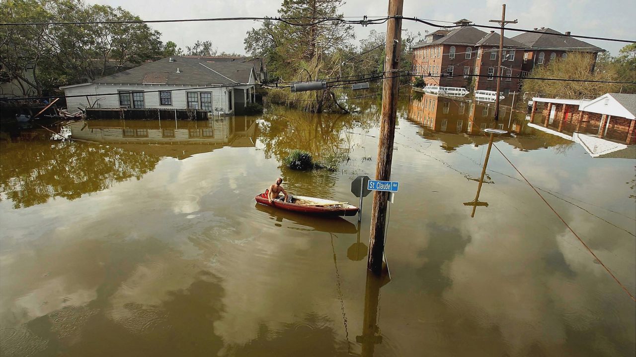 A man in New Orleans' Lower Ninth Ward rides a canoe in high water on August 31, 2005. Hurricane Katrina struck the Gulf Coast on August 29, 2005. After levees and flood walls protecting New Orleans failed, much of the city was underwater. At least 1,833 died in the hurricane and subsequent floods. It was the costliest natural disaster in U.S. history.
