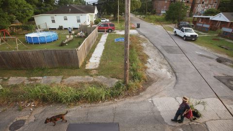 A woman walks with a dog in the Lower Ninth Ward on May 16, 2015.