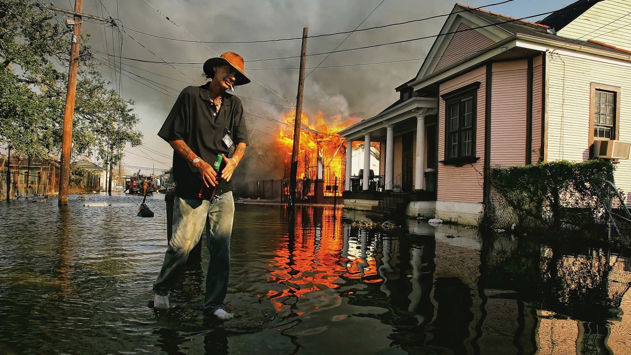 Robert Fontaine walks past a burning house fire in New Orleans' Seventh Ward on September 6, 2005.