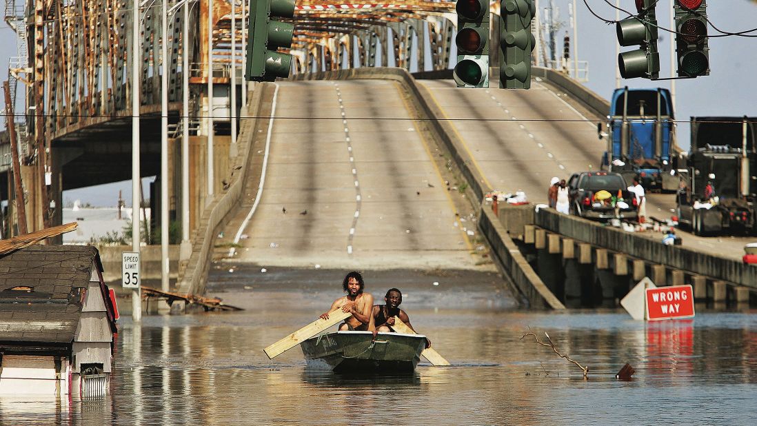 Two men paddle through the streets past the Claiborne Bridge in New Orleans on August 31, 2005.
