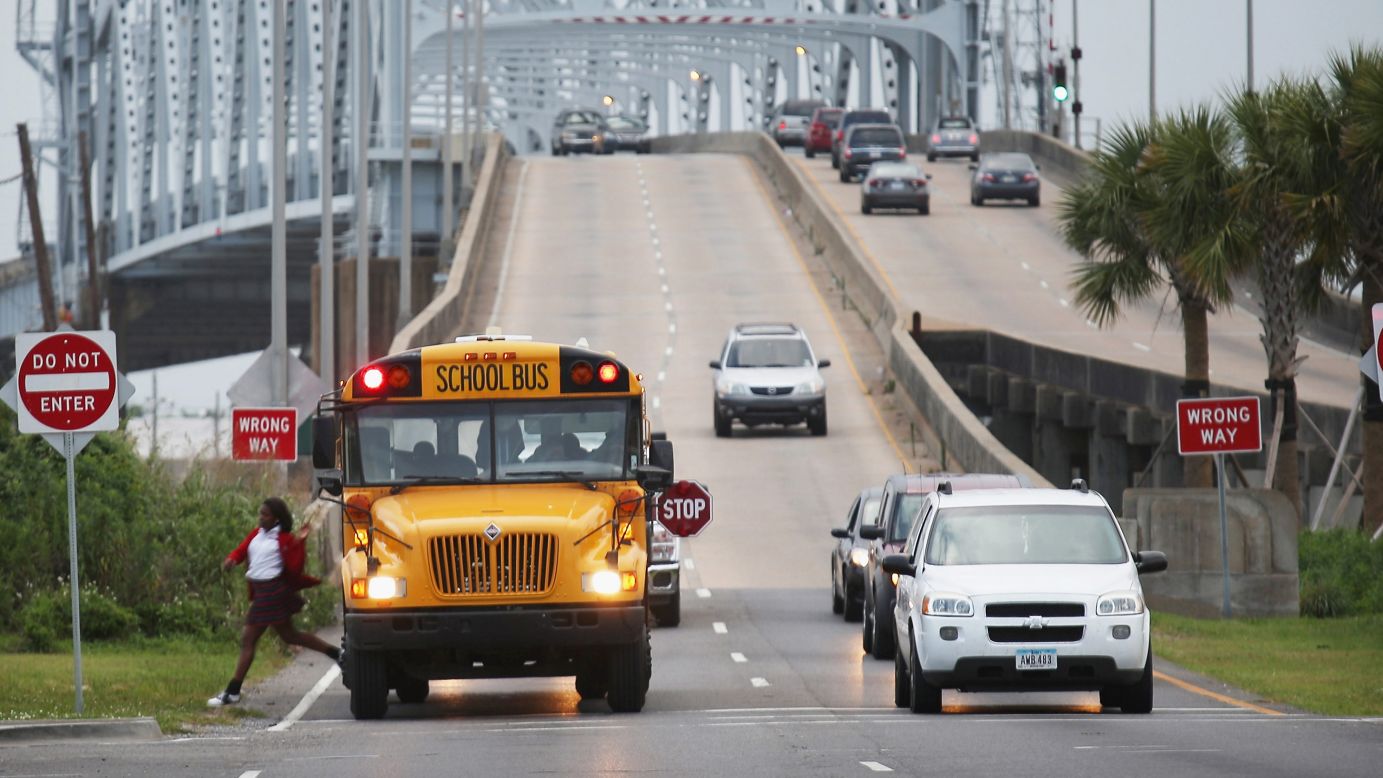 A school bus drops off a student in front of the Claiborne Bridge on May 12, 2015.