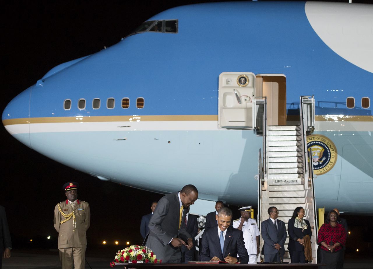 Obama signs a guest book alongside Kenyatta upon arrival at Kenyatta International Airport in Nairobi on Friday, July 24.