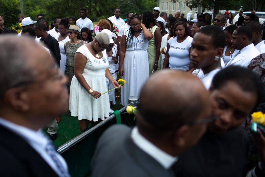 Shavon Bland, the sister of Sandra Bland, holds a flower over her gravesite on July 25. 