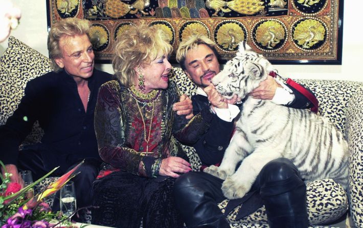 Late actress Elizabeth Taylor (center) greets Atlas, a five-month-old white Siberian tiger with entertainers Siegfried and Roy following their show at the Mirage Hotel and Casino on December 31, 2001.