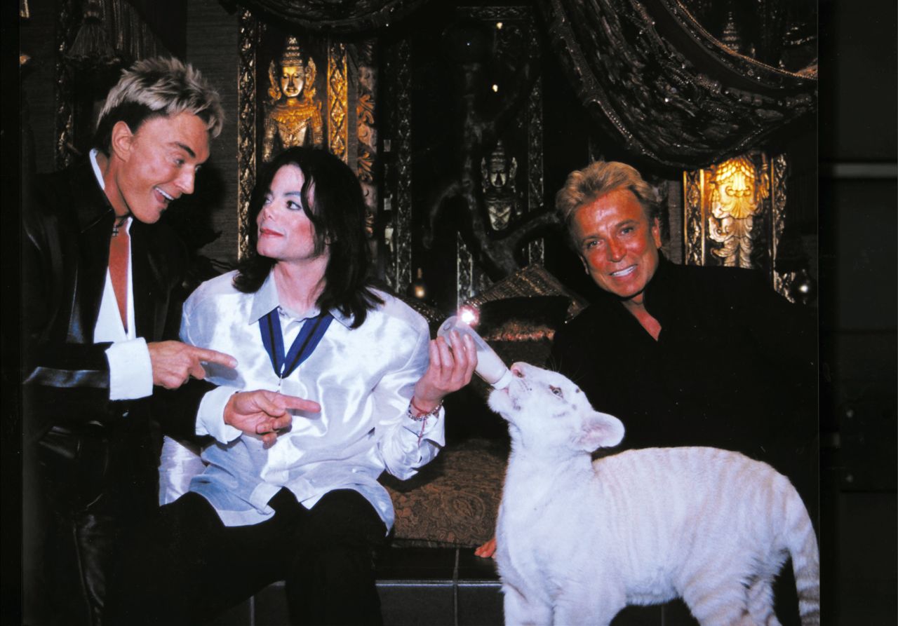 World-renowned illusionists Siegfried (left) and Roy (right) pose with late singer Michael Jackson (center) and Apollo, a rare white Siberian tiger, backstage at the Mirage Hotel and Casino on August 6, 2002 in Las Vegas, Nevada.