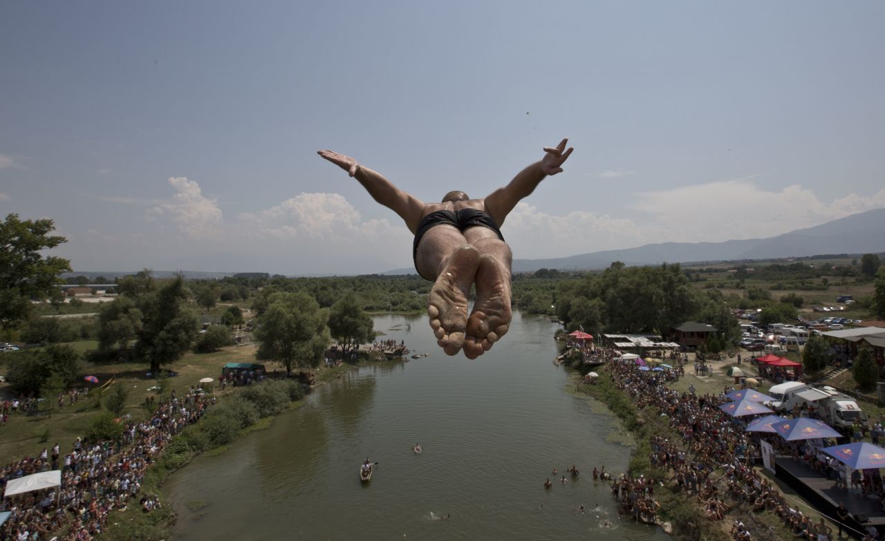 A diver leaps from the Saint Bridge into the Drini i Bardhe river during the annual high diving competition near the town of Gjakova, 100 kilometers south of the Kosovan capital of Pristina, on July 26, 2015. 27 divers from Kosovo took part in the open-air contest this year.