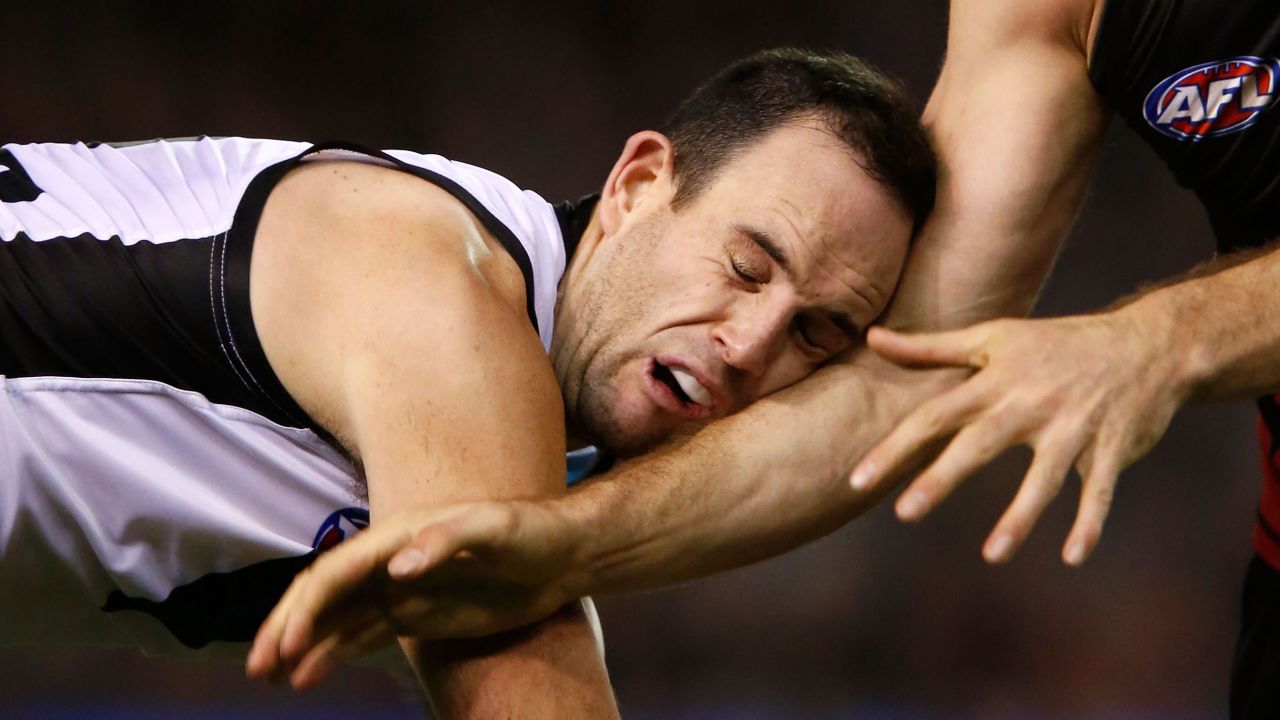 Matthew Broadbent of the Port Adelaide Power is taken down by a tackle during an Australian Football League match Saturday, July 25, in Melbourne.