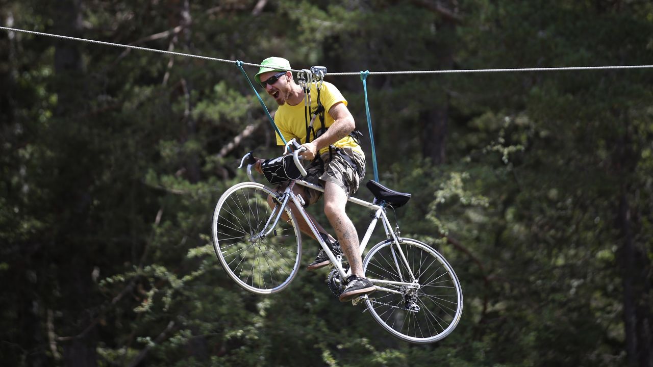 A fan rides a bicycle as he is suspended from a cable during the 17th stage of the Tour de France on Wednesday, July 22.
