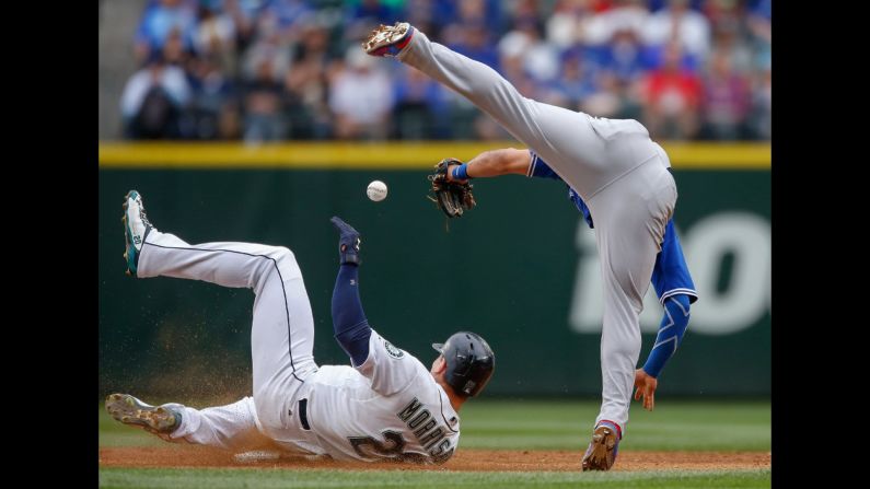 Seattle's Logan Morrison, left, steals second base as Toronto's Devon Travis falls over him on Saturday, July 25.