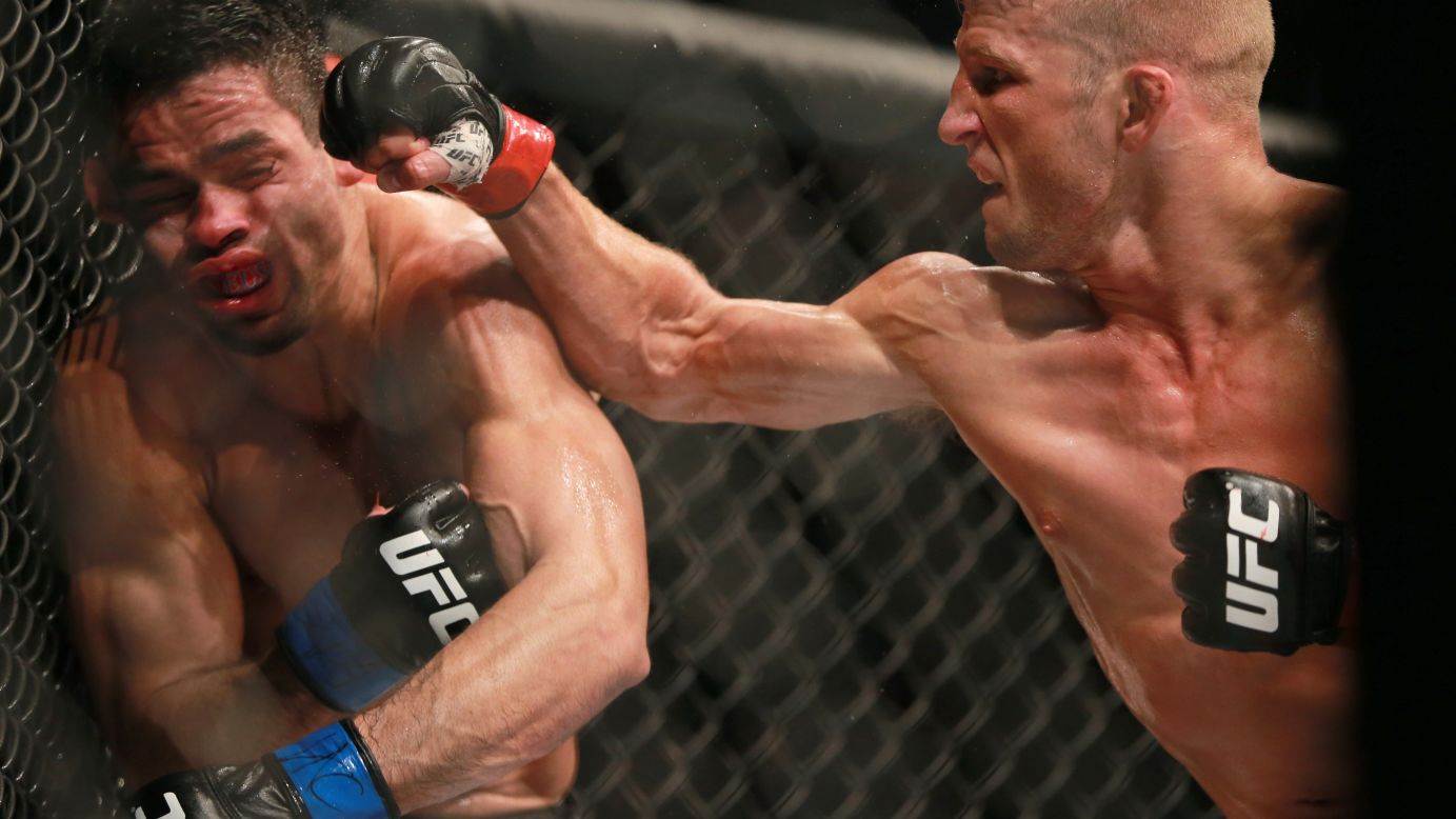 T.J. Dillashaw punches Renan Barao during their UFC bantamweight title bout in Chicago on Saturday, July 25. Dillashaw defended his title with a fourth-round TKO.