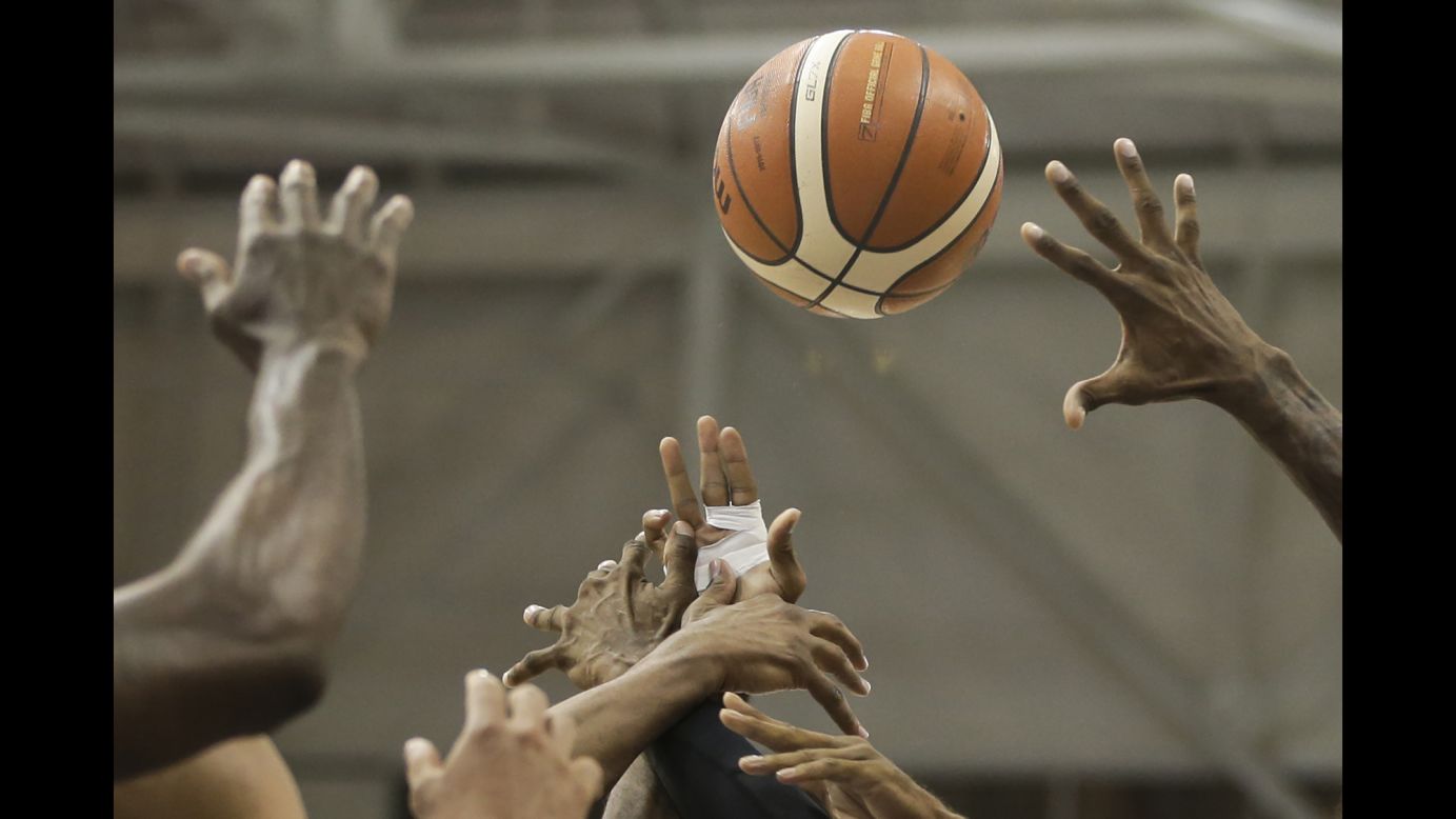 Basketball players from Brazil and the Dominican Republic reach for the ball during their semifinal game at the Pan American Games on Friday, July 24.