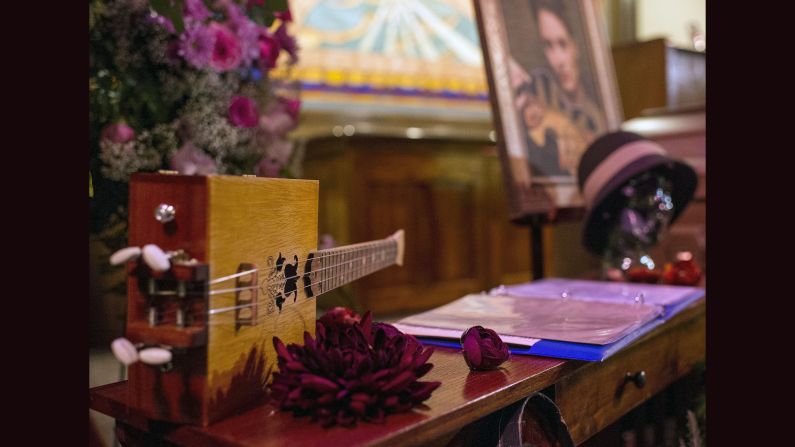 A string instrument and song book are displayed next to the casket of Jillian Johnson. 