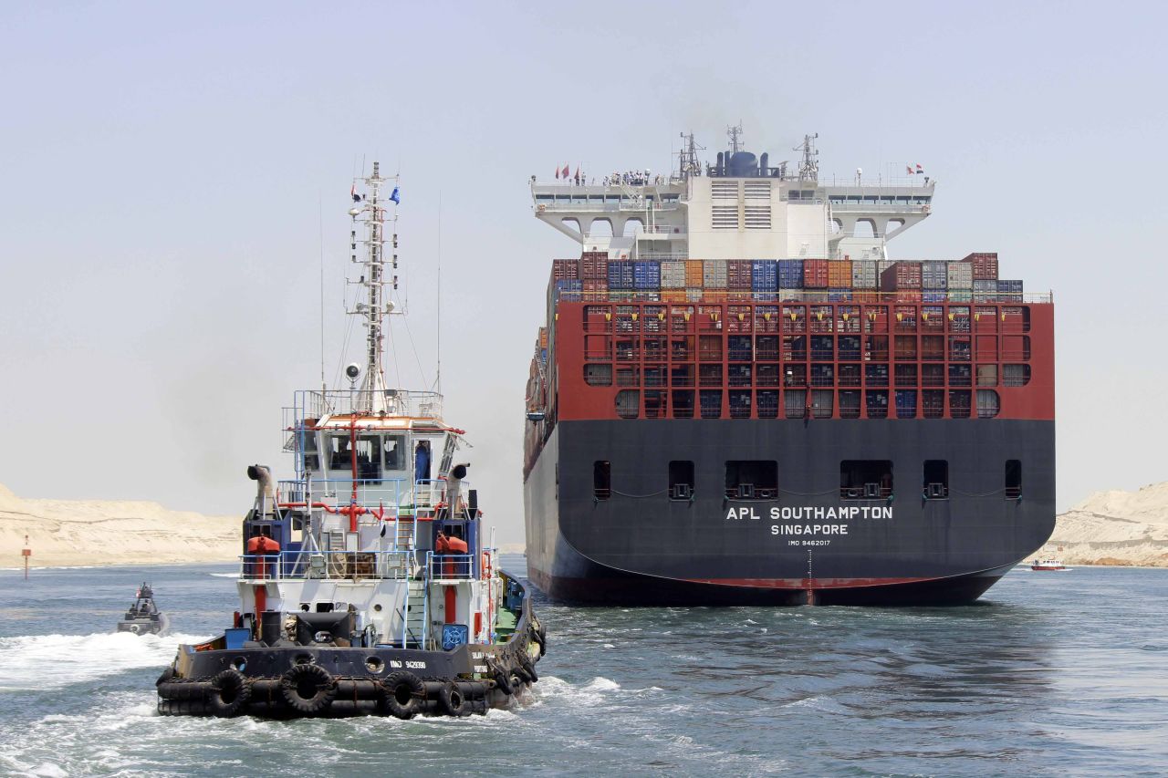 Boats, including a container ship, cross the new waterway of the Suez Canal on July 25, 2015, in the Egyptian port city of Ismailia, east of Cairo. Egypt started the first trial run of its "new Suez canal," officials said, ahead of the new shipping route's formal inauguration on August 6, 2015 -- a year after construction began.