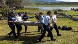 Police carry a piece of debris from an unidentified aircraft found in the coastal area of Saint-Andre de la Reunion, in the east of the French Indian Ocean island of La Reunion, on July 29, 2015. The two-metre-long debris, which appears to be a piece of a wing, was found by employees of an association cleaning the area and handed over to the air transport brigade of the French gendarmerie (BGTA), who have opened an investigation. An air safety expert did not exclude it could be a part of the Malaysia Airlines flight MH370, which went missing in the Indian Ocean on March 8, 2014. AFP PHOTO / YANNICK PITONYANNICK PITON/AFP/Getty Images