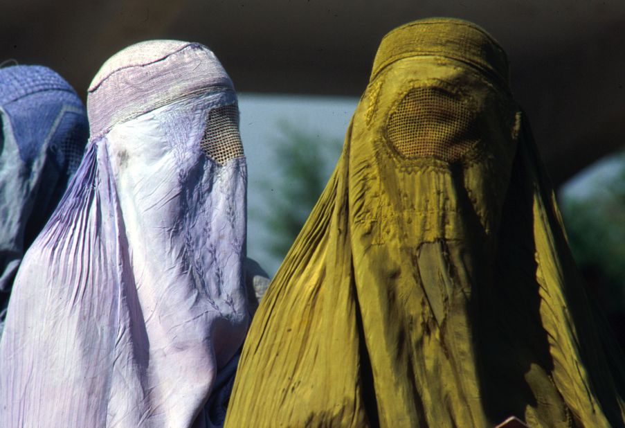 Afghan women in Kabul are covered head to toe in traditional burqas on October 16, 1996. After taking over Kabul, the ruling Taliban imposed strict Islamic laws on the Afghan people. Television, music and non-Islamic holidays were banned. Women were not allowed to attend school or work outside the home, and they were forbidden to travel alone.