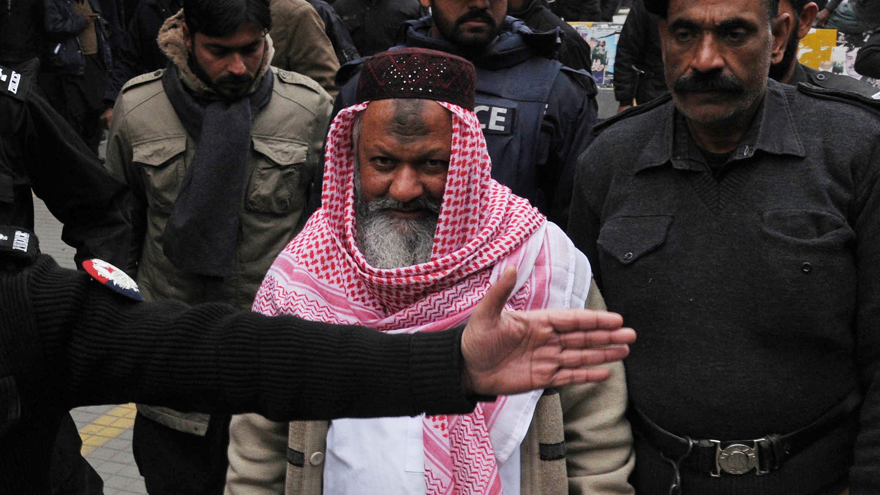 Pakistani police escort Malik Ishaq as he arrives at the high court in Lahore on December 22, 2014.