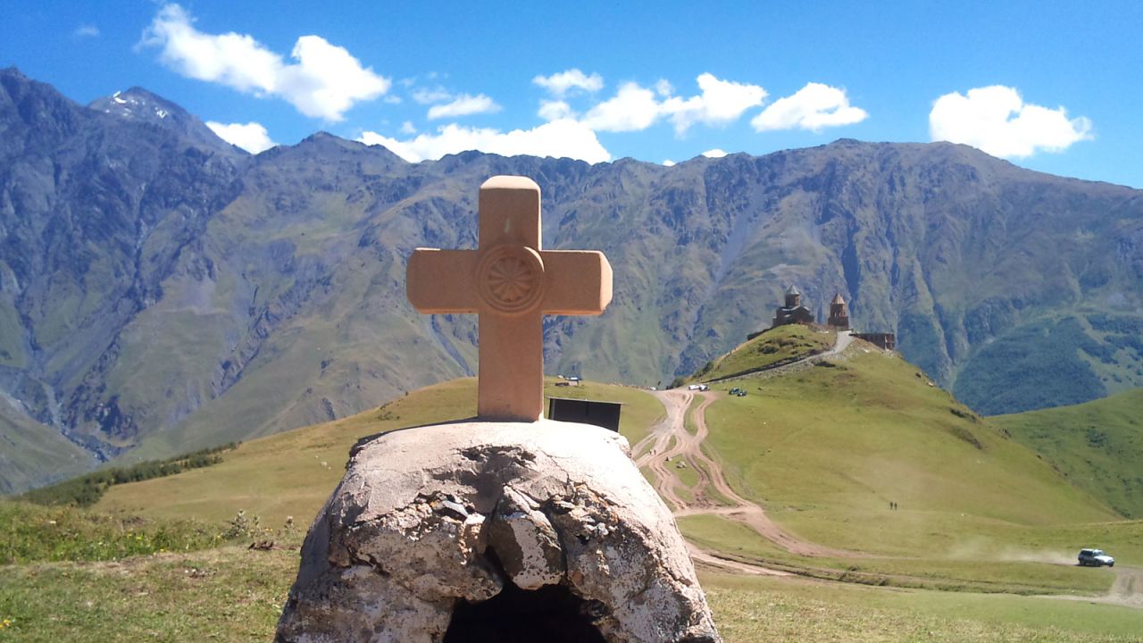 Pictured in the distance, the 14th-century Gergeti Trinity Church is dramatically perched on a hilltop in Kazbegi. It's a two or three-hour hike from the town of Stepantsminda.
