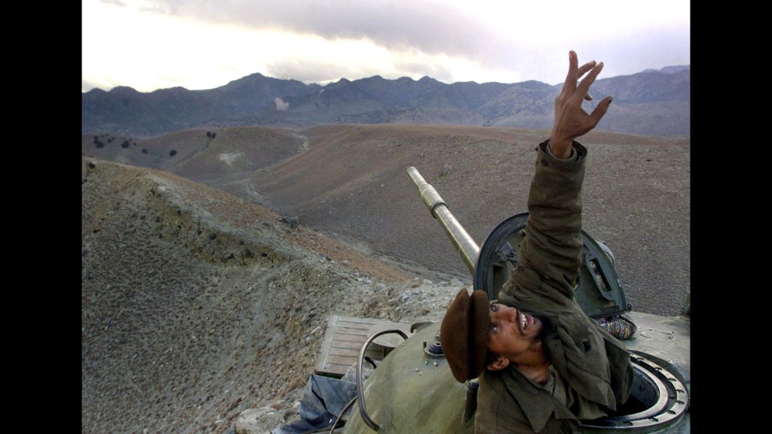 An Afghan anti-Taliban fighter pops up from his tank to spot a U.S. warplane bombing al Qaeda fighters in the Tora Bora region of Afghanistan on December 10, 2001. After massive U.S. bombardment as a part of Operation Enduring Freedom, the Taliban lost Afghanistan to U.S. and Northern Alliance forces.