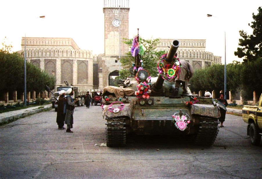 Tanks manned by Taliban fighters are decorated with flowers in front of the presidential palace in Kabul on September 27, 1996.
