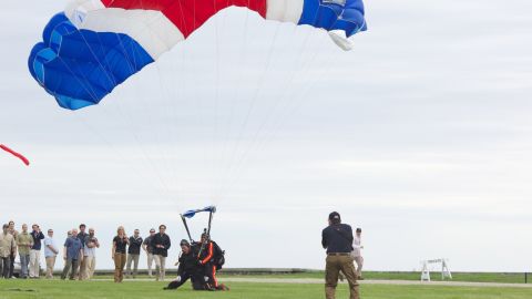 Former U.S. President George H.W. Bush and Mike Elliott, US Army Sergeant 1st Class (ret), land on the lawn at St. Anne's Episcopal Church after jumping out of a helicopter on June 12, 2014 in Kennebunkport, Maine.