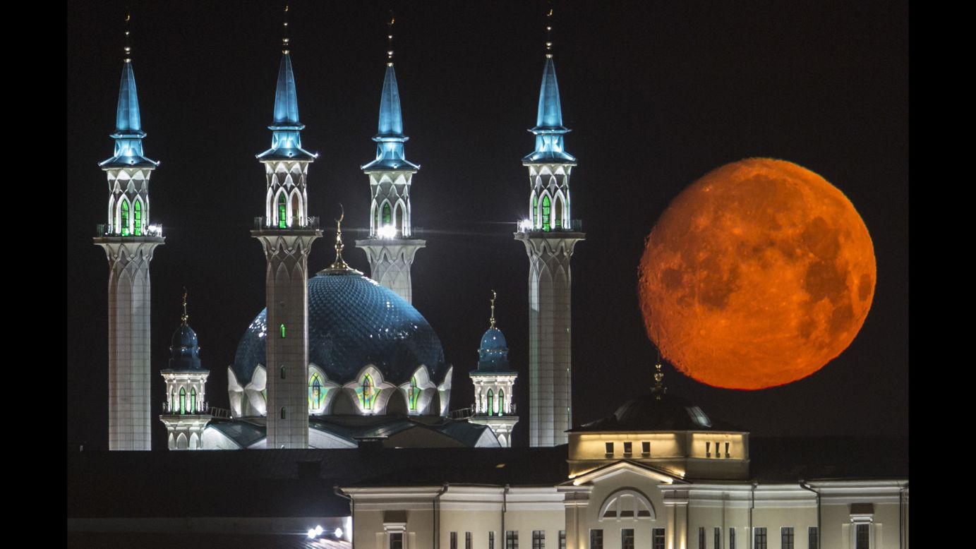 A full moon rises in Kazan, Russia, on Wednesday, July 29. At left is the Qol Sharif mosque.