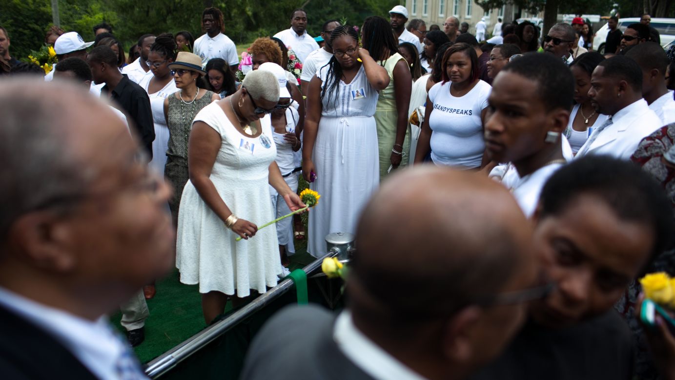 Shavon Bland holds a flower over her sister's gravesite in Willow Springs, Illinois, on Saturday, July 25. <a href="http://www.cnn.com/2015/07/20/us/gallery/sandra-bland-texas-jail-death-vigil/index.html" target="_blank">Sandra Bland</a> was arrested on July 10 for allegedly assaulting an officer during a routine traffic stop. On July 13, she was found dead in her jail cell. Police say the 28-year-old hanged herself with a plastic bag. Her family disputes that.